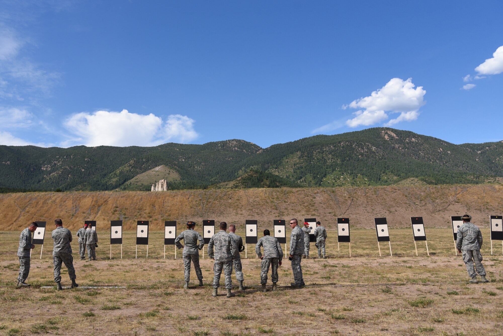 Airmen from the local Colorado area investigate the targets and record their scores with the range safety officials during the Front Range Competition in Excellence Match at the United States Air Force Academy, Colo., Aug. 22, 2016. The top 10 percent of competitors are eligible for the badges, as well as earning four points toward the Distinguished Rifleman or Distinguished Pistol awards. (U.S. Air Force photo by Airman 1st Class Dennis Hoffman)