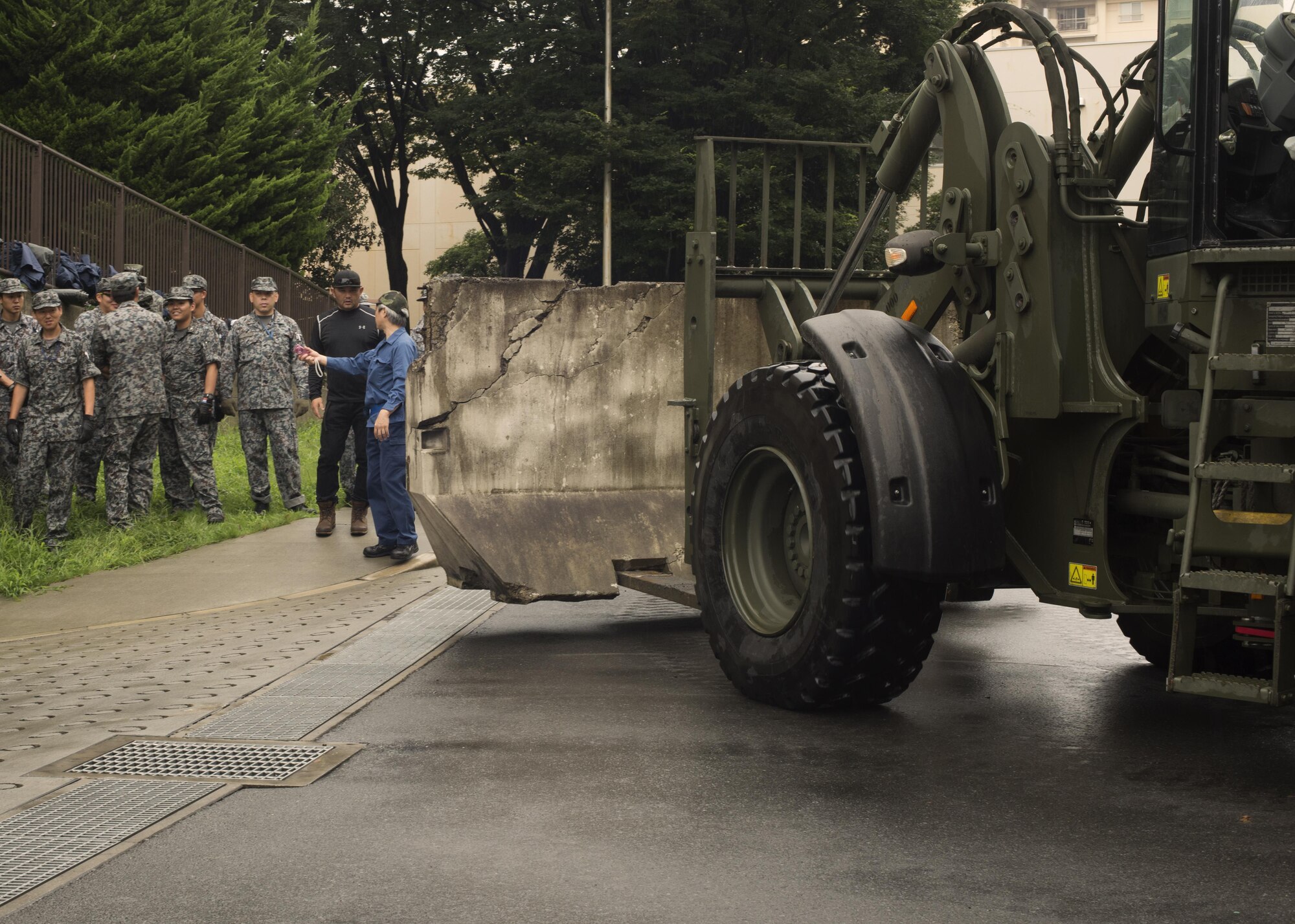 Japan Air Self-Defense Force airmen make way for placement of concrete barriers before placing sandbags in preparations for typhoon Lionrock at Yokota Air Base, Japan, Aug. 29, 2016. Due to damage caused by Typhoon Mindulle that struck Yokota Aug. 22, extra precautions were set in place in preparation for the next typhoon. (U.S. Air Force photo by Airman 1st Class Donald Hudson/Released)