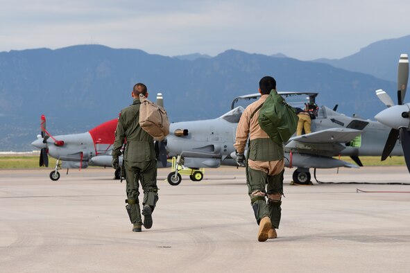 An Afghanistan Air Force pilot, right, joins his trainer for a morning sortie of high-density altitude training in an A-29 Super Tucano at Peterson Air Force Base, Colo., Aug. 24, 2016. The Afghan Air Force is participating in a program training 30 pilots and 90 maintainers for the aircraft, which will be used mainly for close air support functions. (U.S. Air Force photo/Airman 1st Class Dennis Hoffman)