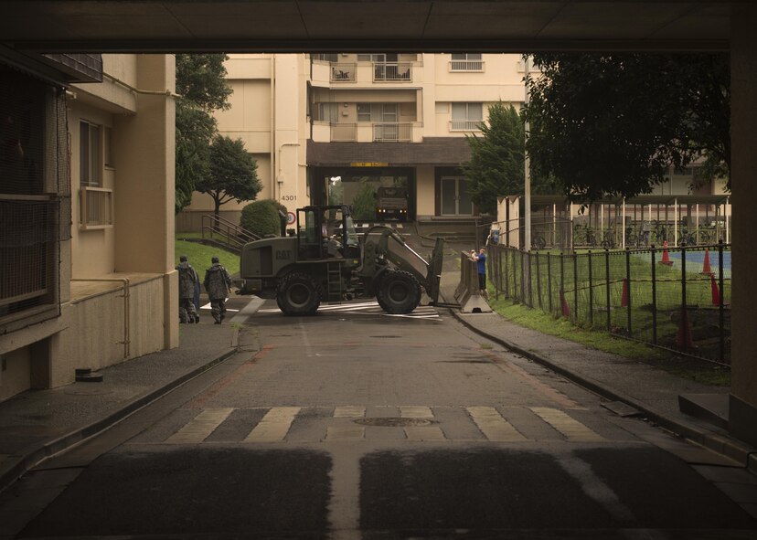 Japan Air Self-Defense Force airmen and U.S. Airmen work together to transport concrete barriers in preparation for Typhoon Lionrock at Yokota Air Base, Japan, Aug. 29, 2016. The work provided by the JASDF airmen and U.S. Airmen helped prepare the base for potential flooding. (U.S. Air Force photo by Airman 1st Class Donald Hudson/Released)