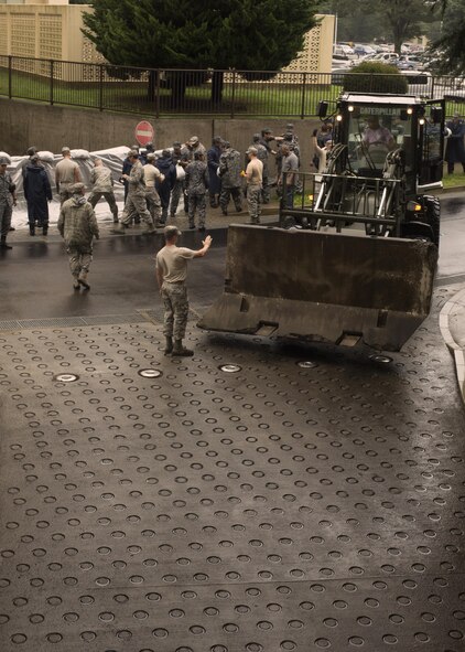 Japan Air Self-Defense Force airmen and U.S. Airmen work together to place sand bags and concrete barriers in preparation for Typhoon Lionrock at Yokota Air Base, Japan, Aug. 29, 2016. The work provided by the JASDF airmen and U.S. Airmen helped prepare the base for potential flooding from Typhoon Lionrock. (U.S. Air Force photo by Airman 1st Class Donald Hudson/Released)