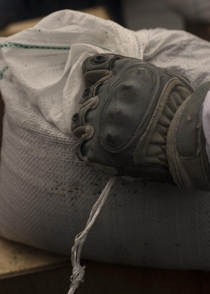 An Airman holds a sand bag before placing it in preparation for Typhoon Lionrock at Yokota Air Base, Japan, Aug. 29, 2016. Approximately 5,000 sand bags were filled and strategically placed around Yokota Air Base by JASDF airmen and U.S. Airmen in preparation for Typhoon Lionrock. (U.S. Air Force photo by Airman 1st Class Donald Hudson/Released)