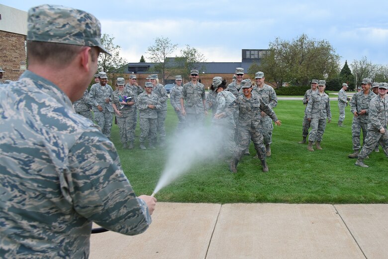 PETERSON AIR FORCE BASE, Colo. – Col. Doug Schiess, 21st Space Wing commander, uses water to hose down Chief Master Sgt. Ida Peele, 21st Space Wing command chief, after an all call at Peterson Air Force Base, Colo., Aug. 23, 2016. Wing personnel gathered to celebrate Peele’s career by sending her off in Air Force heritage fashion.  (U.S. Air Force photo by Airman 1st Class Dennis Hoffman)