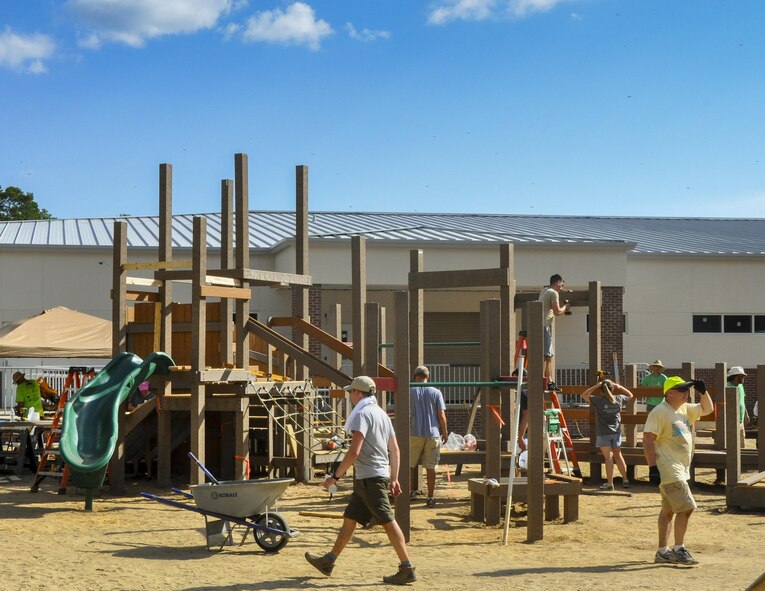 Local military and community volunteers work to construct new playground and therapy equipment at the Emerald Coast Autism Center in Niceville, Fla., Aug. 26.  The volunteers included more than 80 members of the 919th Special Operations Wing who spent a week working on the project to benefit autistic and disabled students at the center on the campus of Northwest Florida State College.  (U.S. Air Force photo/Dan Neely)