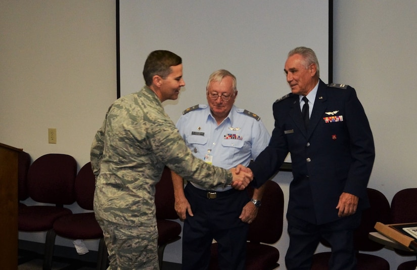 Lt. Col. Eddie Taylor (left) Deputy Commander of the 628th Mission Support Group congratulates Capt. Jim Greco incoming commander of Civil Air Patrol's Coastal Charleston Squadron as Maj. Steve Hyland (Center) outgoing commander, looks on. The change of command ceremony took place August 15, 2016 at Joint Base Charleston, South Carolina.