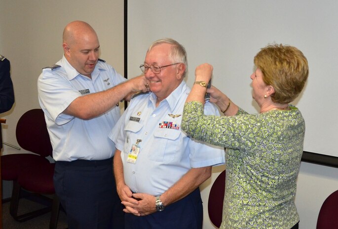 Capt. Steve Hyland (center), outgoing commander of Civil Air Patrol's Coastal Charleston Squadron is promoted to the rank of Maj. by South Carolina Wing Commander, Col. Francis Smith (left), assisted by Betsy Hyland (right). The promotion ceremony was held August 15, 2016 at Joint Base Charleston, South Carolina. (Courtesy photo)