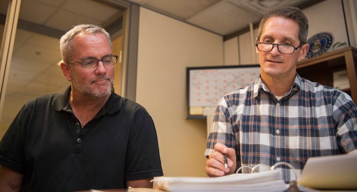 Jim Bailey, Denton logistics manager (left), cross checks the upcoming mission details with Ken Hundemer, Denton operations manager (right), in the Denton program office on Joint Base Charleston – Air Base, S.C., Aug. 30, 2016. The Denton program works with nonprofit organizations to send medical equipment and supplies, nonperishable foods, education materials, hygienic supplies and vehicles to countries in need around the world. (U.S. Air Force photo/Airman 1st Class Thomas T. Charlton)