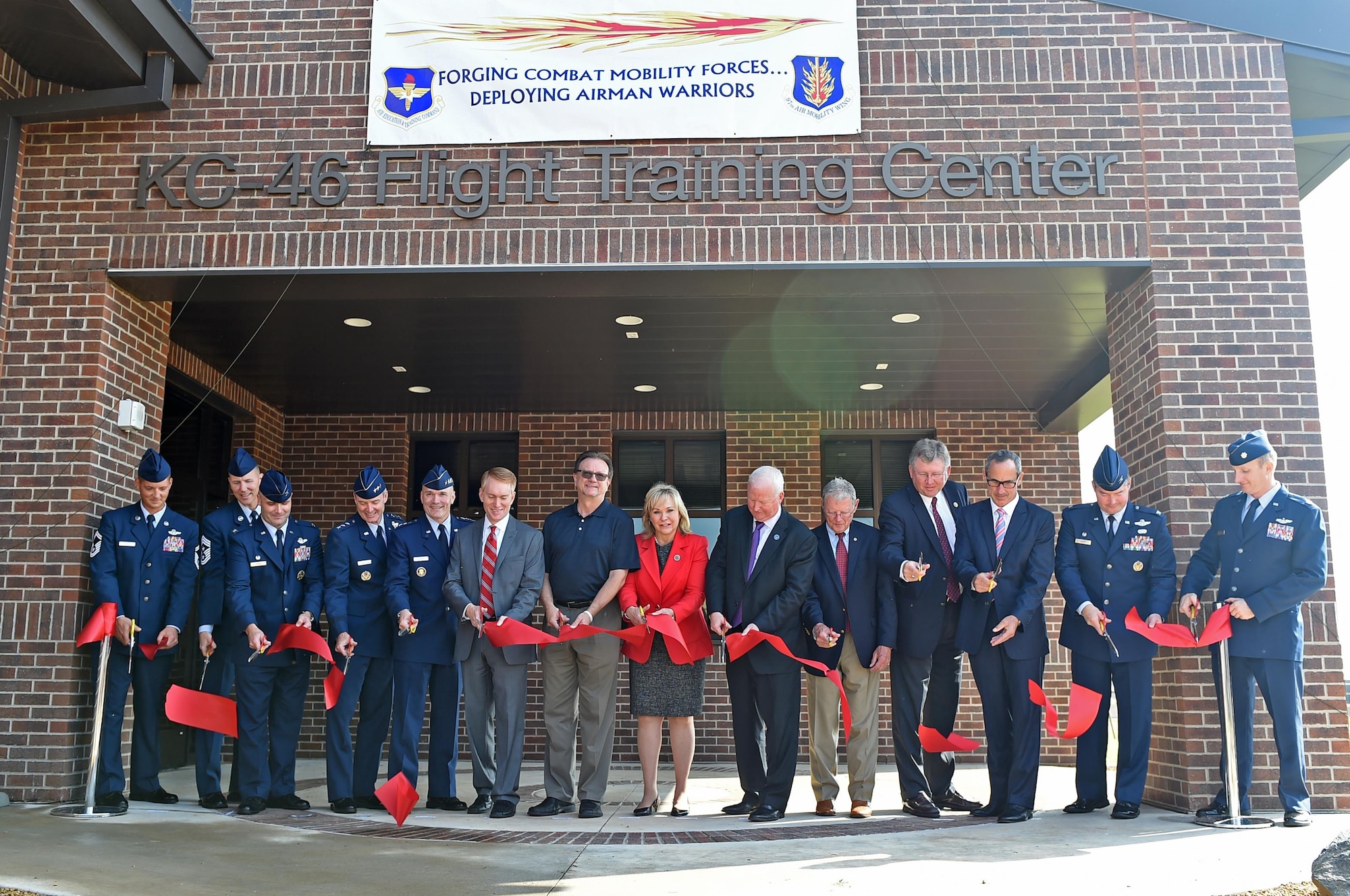 U.S. Air Force leaders and community partners cut a ribbon during the “Forging the 46” ceremony, Aug. 30, 2016, at Altus Air Force Base, Okla. The event consisted of an assumption of command for the reactivated 56th Air Refueling Squadron, dedication of the new KC-46 training facility, speeches from key Air Force and community leaders and concluded with a tour of the new facility for attendees. (U.S. Air Force photo by Senior Airman Dillon Davis)