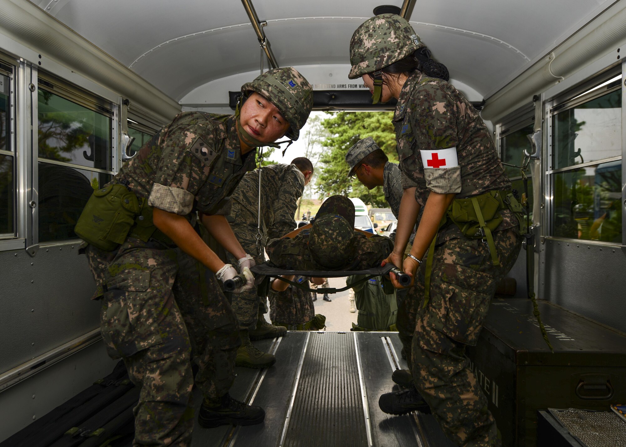 Republic of Korea air force airmen and 51st Medical Group medics raise a simulated bombing victim into a medical transportation bus during a joint mass-casualty medical exercise at Osan Air Base, Republic of Korea, Aug. 22, 2016. The two groups of medics worked side-by-side to triage and transport the simulated victims to proper medical facilities as well as exchange techniques and advice. (U.S. Air Force photo by Senior Airman Victor J. Caputo)