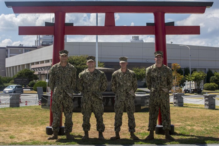 From left to right, Petty Officer 3rd Class Jamison Rigley, a utilities worker, Petty Officer 3rd Class Eli Arwood, a builder, Petty Officer 2nd Class Andrew Jensen, a builder, and Petty Officer 2nd Class Kenneth Lancaster, a steel worker with Headquarters and Headquarters Squadron Facilities pose for a photo outside the 1st Marine Aircraft Wing Vietnam Memorial at Marine Corps Air Station Iwakuni, Japan, Aug. 24, 2016. The Seabees pressure washed the area; chipped off any loose materials such as concrete, paint or rust; removed the chains and stripped them down to bare steel; and patched the monument with a mortar mix before repainting the chains and hand brushing the monument. (U.S. Marine Corps photo by Lance Cpl. Aaron Henson)