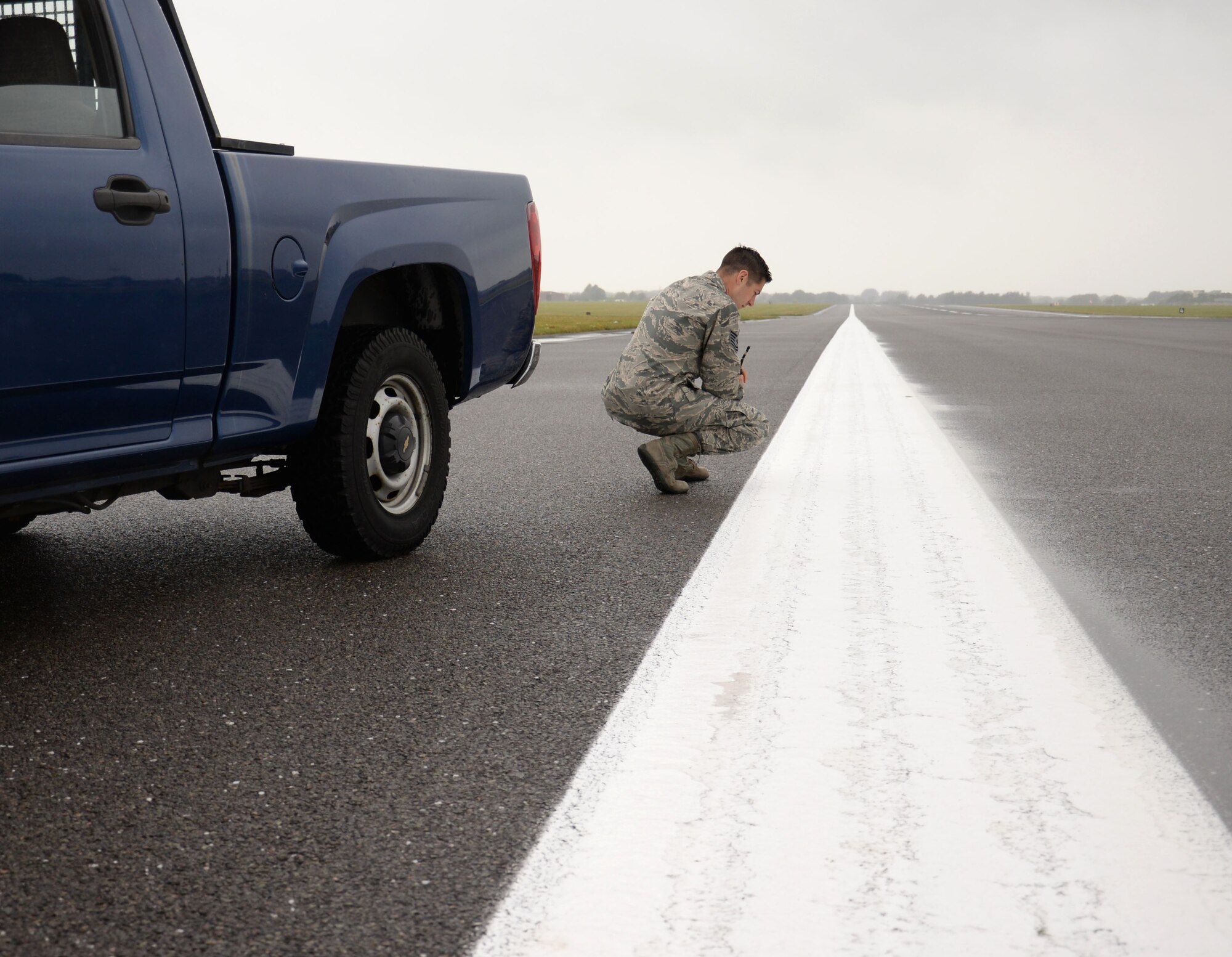 U.S. Air Force Tech. Sgt. Joshua Johnson, 100th Operations Support Squadron NCO in charge of Airfield Management training, checks the paint on the runway Aug. 11, 2016, on RAF Mildenhall, England. Johnson deals with safety orientated airfield management such as inspecting the runways, the taxiways, and making sure there are no pavement deficiencies. (U.S. Air Force photo by Gina Randall)