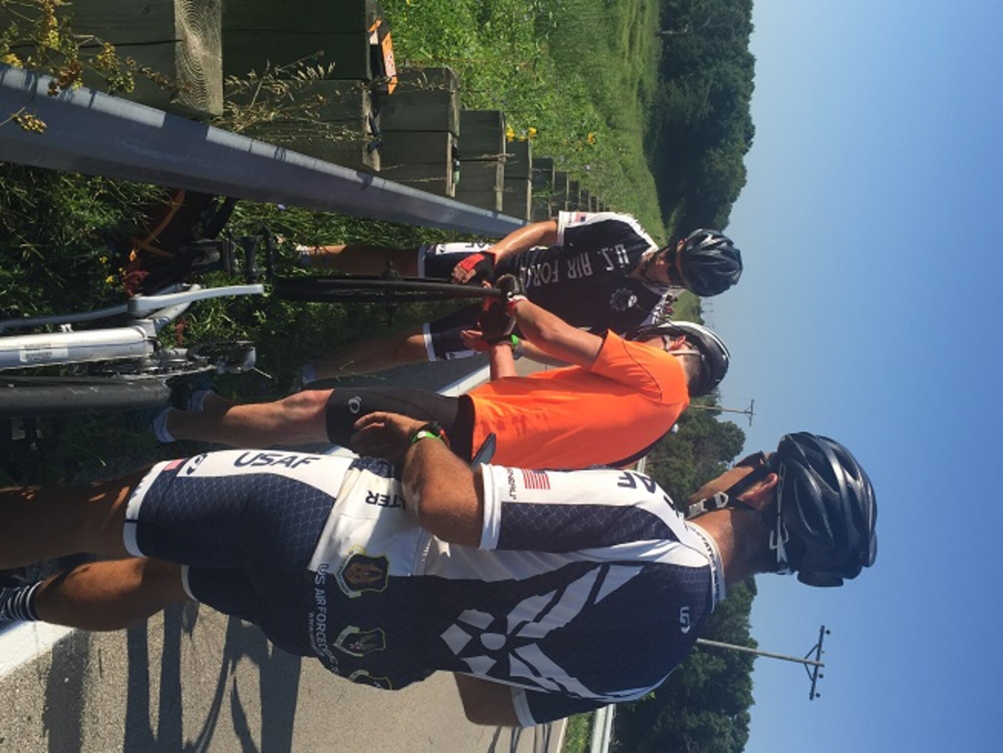 U.S. Air Force Tech. Sgt. Joshua Johnson, left, 100th Operations Support Squadron NCO in charge of Airfield Management training, helps another cycler by replacing a tube in a tire during the Register’s Annual Bicycle Ride across Iowa July 28, 2016, in Iowa. The Air Force team enjoyed the ride while helping others along the way. (Courtesy photo)