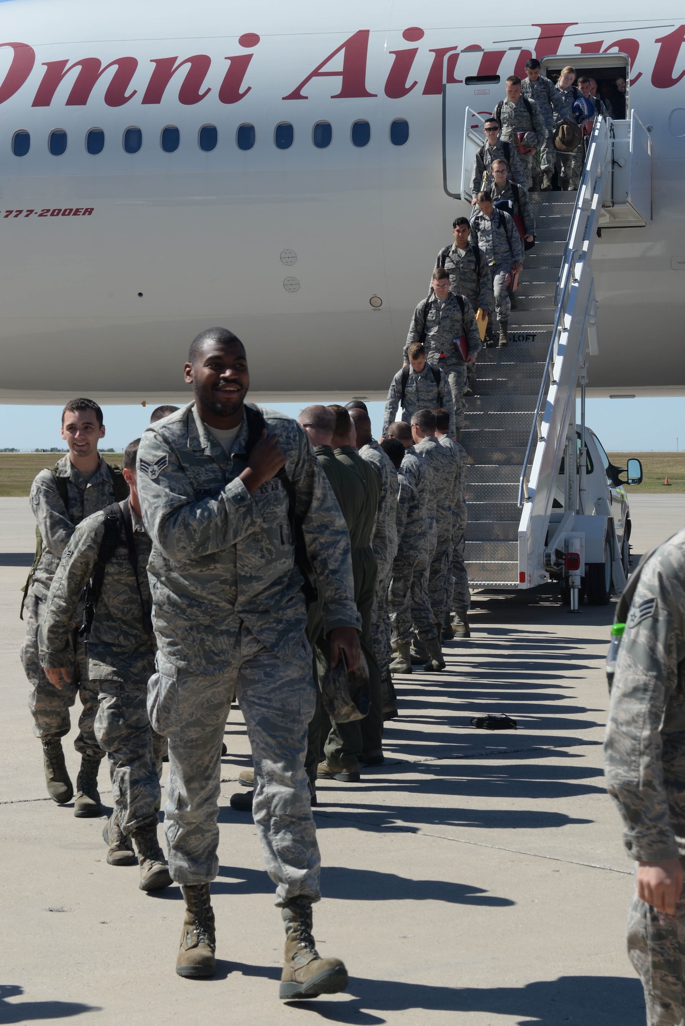 Airmen depart a Boeing 777 after a six-month deployment and are greeted by base leadership at Minot Air Force Base, N.D., Aug. 29, 2016. This is the last known rotation for B-52 continuous bomber presence at Andersen AFB, Guam. (U.S. Air Force Photo/Airman 1st Class Jessica Weissman)