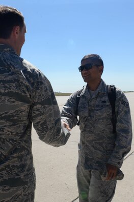 Senior Airman Kawika Kekaualua, an Airman assigned to the 5th Aircraft Maintenance Squadron, is greeted by Col. Matthew Brooks, 5th Bomb Wing commander, after returning home from deployment at Minot Air Force Base, N.D., Aug. 29, 2016. Over 300 Airmen were welcomed by base leadership, family and friends. (U.S. Air Force Photo/Airman 1st Class Jessica Weissman)