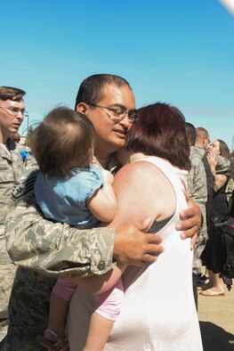 Staff Sgt. Michael McCarty, an Airman assigned to the 5th Munitions Squadron, reunites with his family at Minot Air Force Base, N.D., Aug. 29, 2016. Various Minot AFB Airmen were deployed to Andersen AFB, Guam, in support of the continuous bomber presence. (U.S. Air Force Photo/Airman 1st Class Jessica Weissman)