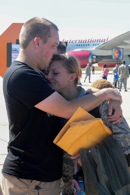 Senior Airman Rebecca Gibson, an Airman assigned to the 5th Munitions Squadron, embraces her husband at Minot Air Force Base, N.D., Aug. 29, 2016. Various Minot AFB Airmen were deployed to Andersen AFB, Guam, in support of the continuous bomber presence. (U.S. Air Force Photo/Airman 1st Class Jessica Weissman)