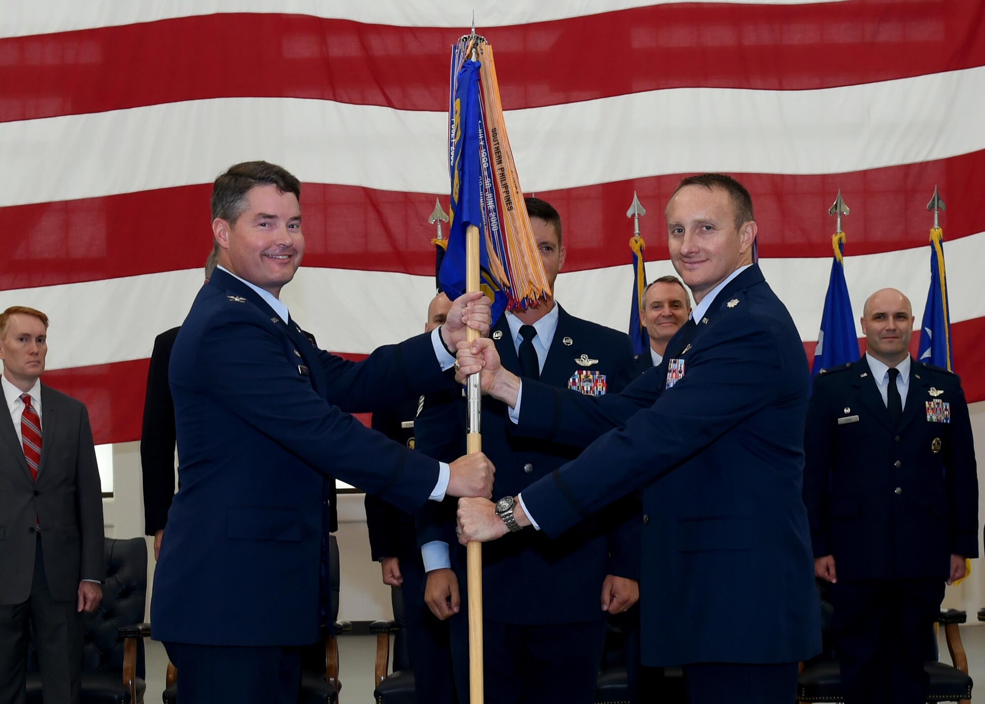 U.S. Air Force Col. Bryan Wood [left], 97th Operations Group commander, passes the guidon for the 56th Air Refueling Squadron to U.S. Air Force Lt. Col. Daniel Ruttenber [right], 56th ARS commander, during the “Forging the 46” ceremony, Aug. 30, 2016, at Altus Air Force Base, Okla. The event consisted of an assumption of command for the reactivated 56th ARS, dedication of the new KC-46 training facility, speeches from key Air Force and community leaders and concluded with a tour of the new facility for attendees. (U.S. Air Force photo by Airman 1st Class Kirby Turbak/Released)   