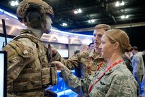Event attendees, Maj. Jonothan Greene and Maj. Amy McQuitty, look over a uniform display during the Air Force Information Technology and Cyberpower Conference, Aug. 29, 2016, in Montgomery, Ala. Over 100 vendors were present during the AFITC vendor exhibit to showcase their latest ideas. (US Air Force photo by Melanie Rodgers Cox)