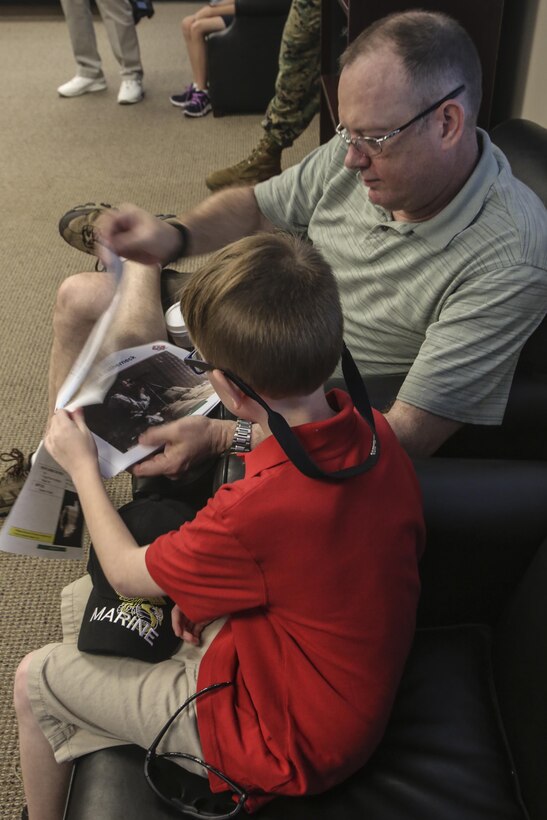 Retired Marine Sgt. Patrick Melton looks at a presentation with his son as part of a reunion for 1st Battalion, 6th Marine Regiment veterans who survived a helicopter crash while attached the 22nd Marine Expeditionary Unit in 1986. The surviving veterans gathered at Camp Lejeune, N.C., Aug. 29, 2016 to watch static displays and receive tours around 6th Marine Regiment to show the changes to units since the veterans were stationed there. (U.S. Marine Corps photo by Lance Cpl. Miranda Faughn)