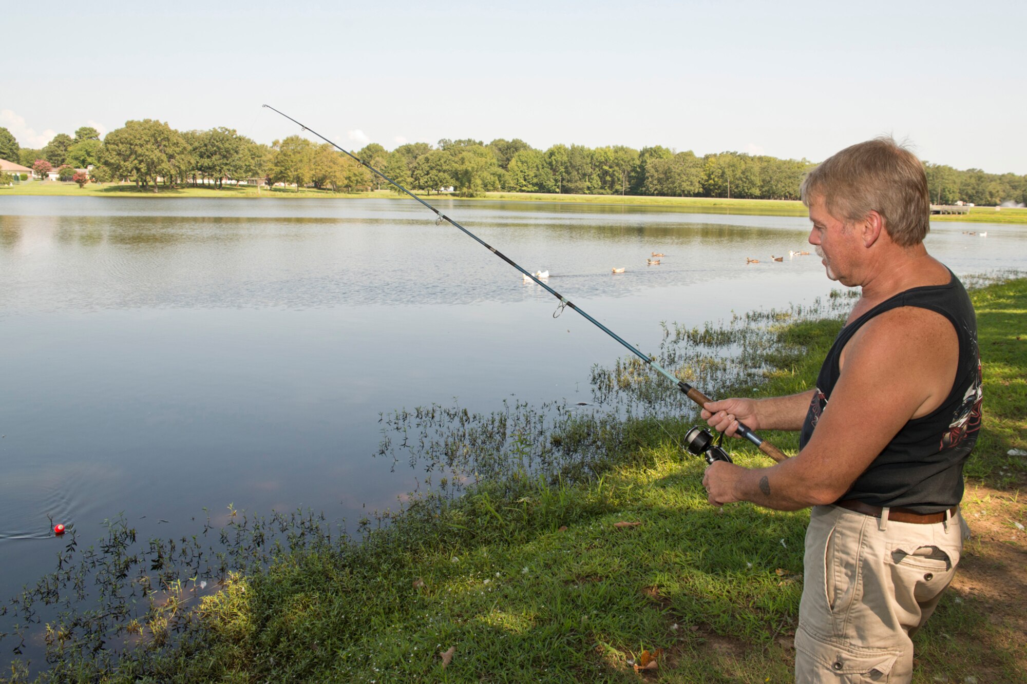 Retired U.S. Army Sgt. 1st Class Kevin Delong, reels in his bait at Kenneth “Pat” Wilson Lake on Little Rock Air Force Base, Ark., Aug. 30, 2016. Delong drove down to Arkansas from Upstate New York for a visit with his daughter Melanie and son-in-law Staff Sgt. Matthew Floyd, an aircrew flight equipment craftsman assigned to the 19th Operations Support Squadron. (U.S. Air Force photo by Master Sgt. Jeff Walston/Released)  