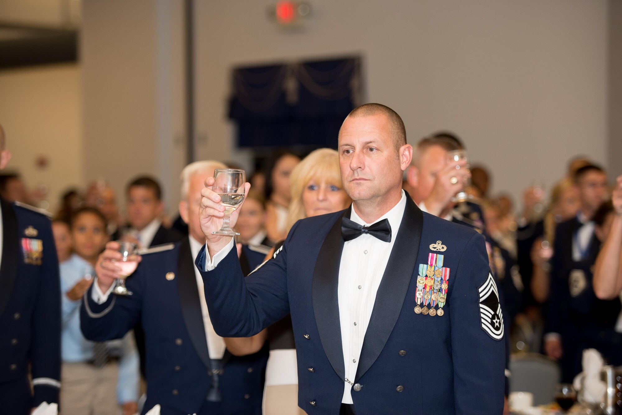 Attendees of the 2016 Dover Air Force Base Senior NCO Induction Ceremony raise a toast in honor of U.S. prisoners of war and service members missing in action Aug. 26, 2016, at Dover Air Force Base, Del. The Senior NCO corps is comprised of master sergeants, senior master sergeants and chief master sergeants. (U.S. Air Force photo by Mauricio Campino)