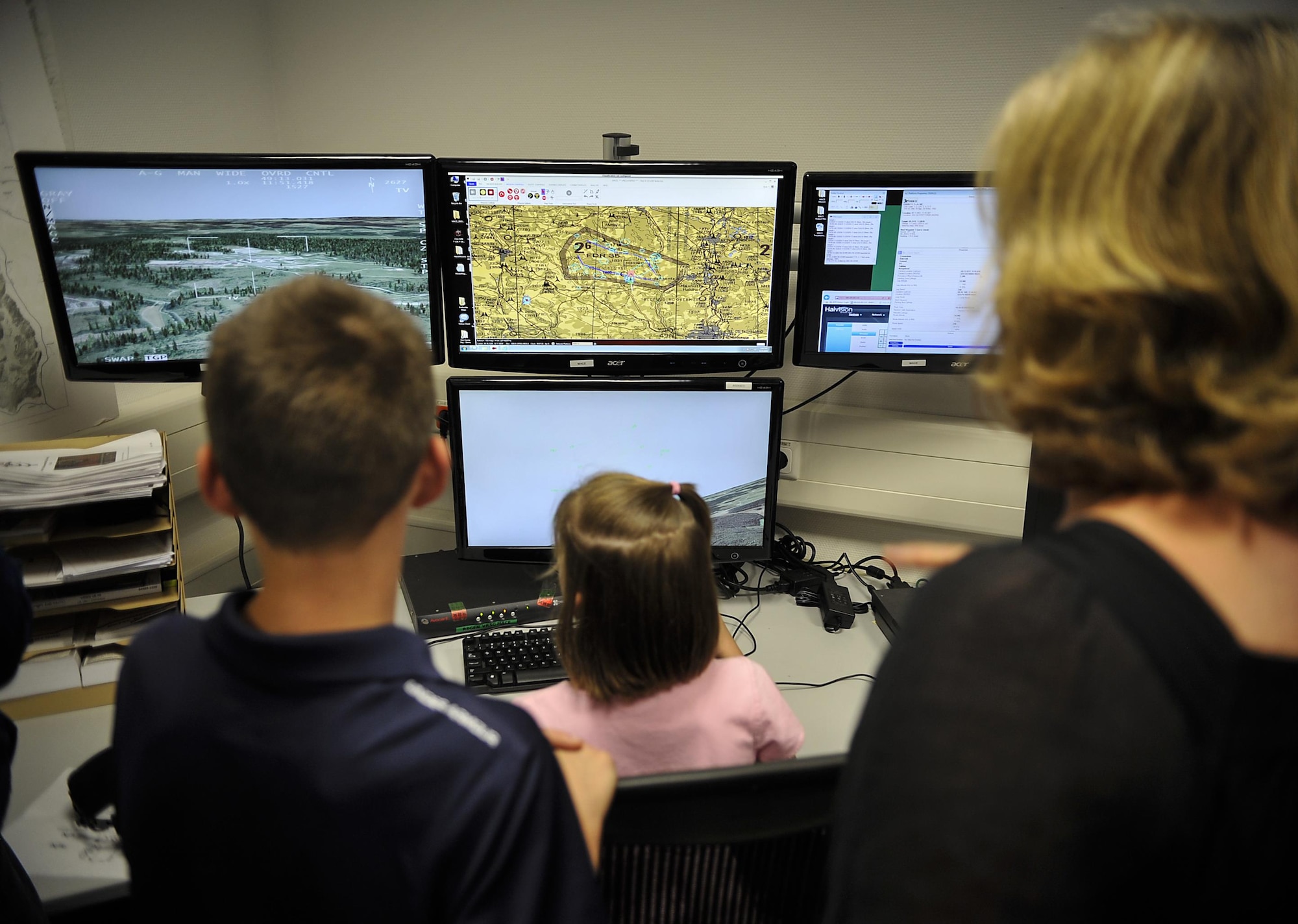 Family members test out a flying simulation during an open house Aug. 25, 2016, at Einsiedlerhof Air Station, Germany. The simulators allow Warrior Preparation Center Airmen to train in-house without risk of life or limb. (U.S. Air Force photo/Senior Airman Larissa Greatwood)
