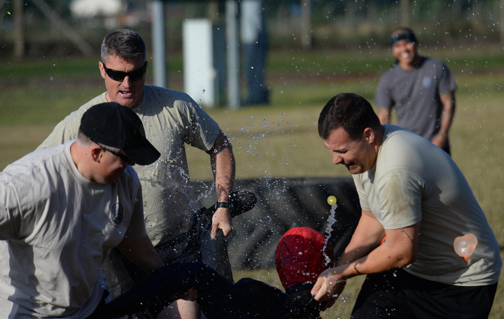 Air commandos from the 352d Special Operations Wing drag a dummy during the Highland Games Sports and Family Day Aug. 26, 2016, on RAF Mildenhall, England. The event opened with a leadership relay race where participants had to sprint, flip a tire and carry a dummy across the finish line while competitors threw water balloons. (U.S. Air Force photo by Staff Sgt. Micaiah Anthony)