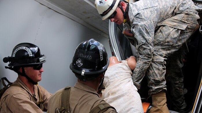 PERRY, Ga. – Marines with technical rescue platoon, Chemical Biological Incident Response Force, CBIRF, work with soldiers from the 911th Technical Rescue Engineer Company Fort Belvoir, Va., transport simulated casualties rescued using extrication techniques during Exercise Scarlet Response 2016 at Guardian Centers, Perry, Ga., Aug. 23, 2016. This exercise is the unit’s capstone event, testing the levels of each individual CBIRF capability with lane training and culminating with a 36-hour simulated response to a nuclear detonation. CBIRF is an active duty Marine Corps unit that, when directed, forward-deploys and/or responds with minimal warning to a chemical, biological, radiological, nuclear or high-yield explosive threat or event in order to assist local, state, or federal agencies and the geographic combatant commanders in the conduct of CBRNE response or consequence management operations, providing capabilities for command and control; agent detection and identification; search, rescue, and decontamination; and emergency medical care for contaminated personnel. (Official U.S. Marine Corps photo by Lance Cpl. Maverick S. Mejia/RELEASED)