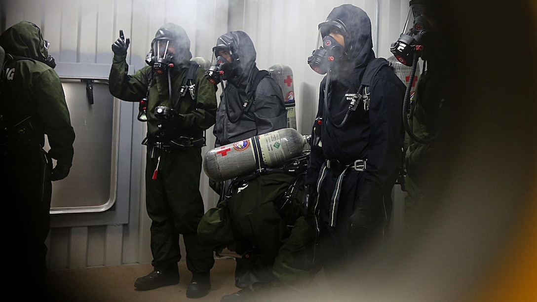 Sailors with Chemical Biological Incident Response Force, CBIRF, examine a contaminated chamber using a Multi-Rae monitor while donning their Class A personal protective equipment which includes self-contained breathing apparatus during Exercise Scarlet Response 2016 at Guardian Centers, Perry, Ga., Aug. 23, 2016.   This exercise is the unit’s capstone event, testing the levels of each individual CBIRF capability with lane training and culminating with a 36-hour simulated response to a nuclear detonation. CBIRF is an active duty Marine Corps unit that, when directed, forward-deploys and/or responds with minimal warning to a chemical, biological, radiological, nuclear or high-yield explosive threat or event in order to assist local, state, or federal agencies and the geographic combatant commanders in the conduct of CBRNE response or consequence management operations, providing capabilities for command and control; agent detection and identification; search, rescue, and decontamination; and emergency medical care for contaminated personnel.