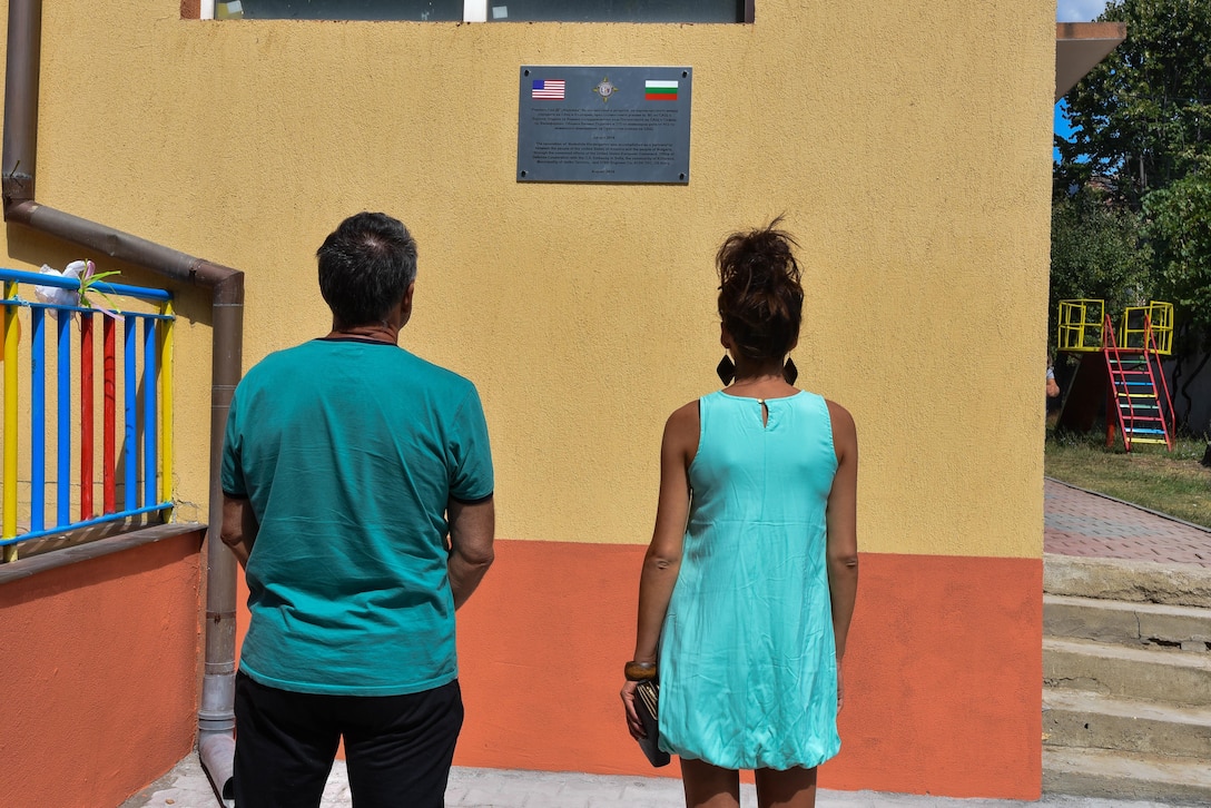 Kindergarten parents read the commemorative plaque attached to the kindergarten wall during a Humanitarian Civil Assistance project, Kalifarevo, Bulgaria, Aug. 26, 2016. As a part of the European Command’s (EUCOM) Humanitarian a Civic Assistance Program, the U.S. Army reserve 457th Civil Affairs Battalion, the 375th Engineer Company, U.S. Air Force National Guard 164th Civil Engineer Squadron and the Bulgarian Army collaborate to renovate a Kindergarten. The Humanitarian and Civic Assistance Program is a series of medical and engineering engagements in several European countries in support of strategic, theater, operational and tactical objectives. (U.S. Army photo by Spc. Nathanael Mercado)