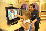 Treasea Landreth (right), child youth program assistant, helps Elizabeth Hernandez navigate through a computer program Aug. 17, 2016 at the Joint Base San Antonio-Randolph Child Development Center. Following a lengthy construction and renovation project which doubled the space of its two facilities, the CDP will accommodate 282 children – 192 at its main building on New B Street West and 90 at its annex on H Street.

