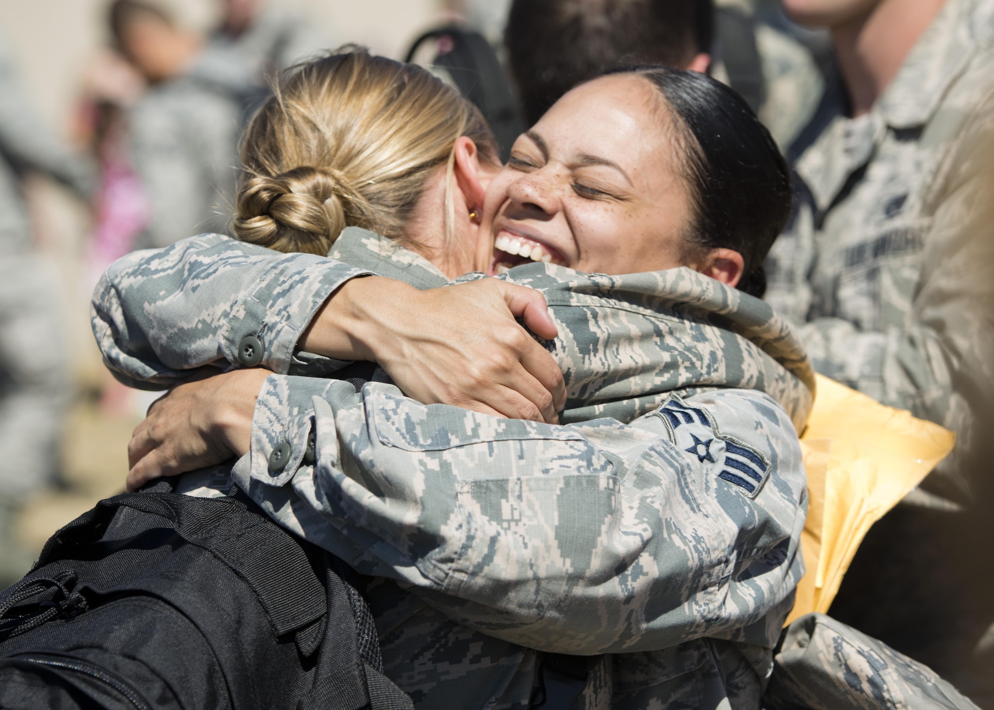 Airmen embrace after returning home from a deployment at Dock 9 at Minot Air Force Base, N.D., Aug. 29, 2016. Airmen from the 5th Bomb Wing were deployed to Andersen Air Force Base, Guam, in support of the continuous bomber presence. (U.S. Air Force photo/Airman 1st Class J.T. Armstrong)