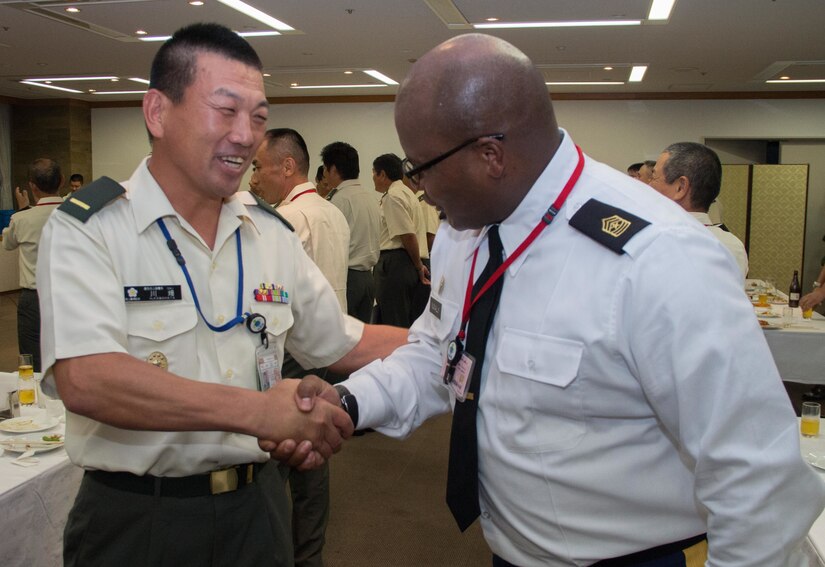 Sgt. Maj. Bennie Nunnally (right), senior enlisted advisor, Army Reserve Engagement Team-Japan, shakes hands with Warrant Officer Himori Kawahata (left), command sergeant major of the Japan Ground Self-Defense Force, during a formal dinner hosted at the Sky View Restaurant in Camp Ichigaya, Japan, Aug. 29, 2016. The JGSDF senior leadership selected approximately 60 Reserve Component service members to Camp Ichigaya to participate in a week-long symposium that promoted esprit de corps between the reserve and active duty component through classroom assignments, field exercises and social events. The JGSDF invited Nunnally to speak about the mission and capabilities of the U.S. Army Reserve and how they enhance the bilateral partnership between Japan and the United States. (U.S. Army photo by Sgt. John Carkeet, U.S. Army Japan)