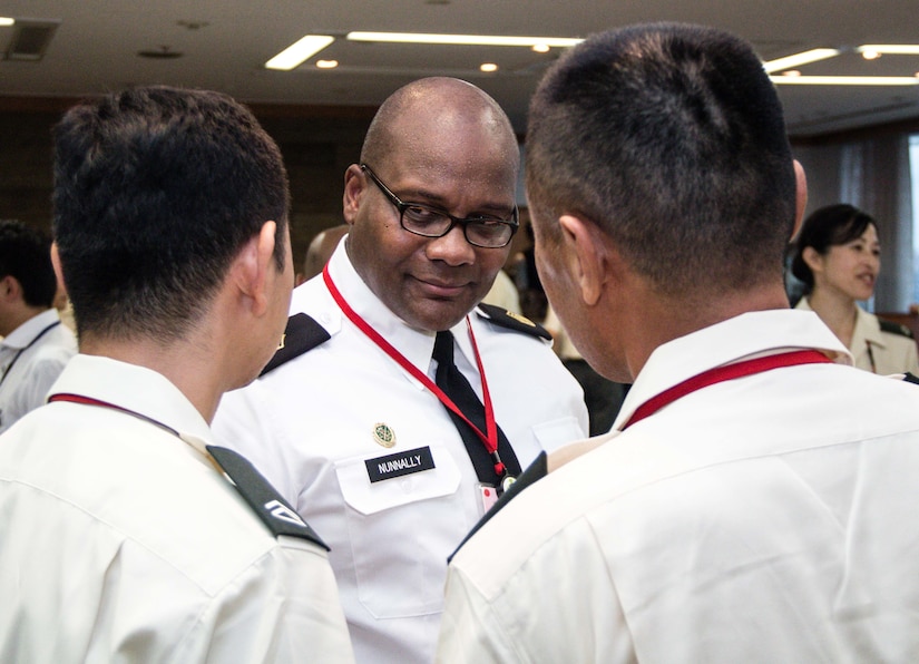 Sgt. Maj. Bennie Nunnally, senior enlisted advisor, Army Reserve Engagement Team-Japan, discusses the role of the noncommissioned officer with his Japan Ground Self Defense Force Reserve Component counterparts during a formal dinner hosted at the Sky View Restaurant in Camp Ichigaya, Japan, Aug. 29, 2016. The JGSDF senior leadership selected approximately 60 Reserve Component service members to Camp Ichigaya to participate in a week-long symposium that promoted esprit de corps between the reserve and active duty component through classroom assignments, field exercises and social events. The JGSDF invited Nunnally to speak about the mission and capabilities of the U.S. Army Reserve and how they enhance the bilateral partnership between Japan and the United States. (U.S. Army photo by Sgt. John Carkeet, U.S. Army Japan)