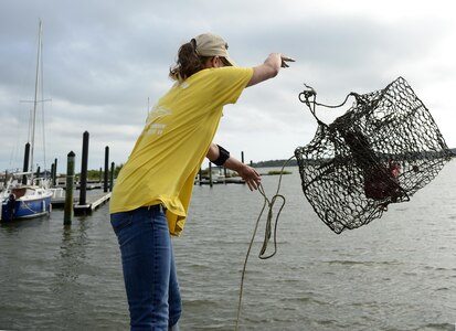 Amy Wood, 633rd Force Support Squadron marina staff member, throws a crab trap off the fishing pier at the marina at Langley Air Force Base, Va., Aug. 29, 2016.  Along with fishing, the marina provides “Anchor Down” events every Friday with assorted beverages, food specials and a bounce house. (U.S. Air Force photo by Airman 1st Class Kaylee Dubois)