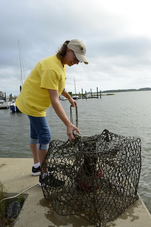 Amy Wood, 633rd Force Support Squadron marina staff member, checks a crab trap at the fishing pier off of the marina at Langley Air Force Base, Va., Aug. 29, 2016. Fishing is allowed off of designated areas around the marina, it also supplies a fish-cleaning station. (U.S. Air Force photo by Airman 1st Class Kaylee Dubois)