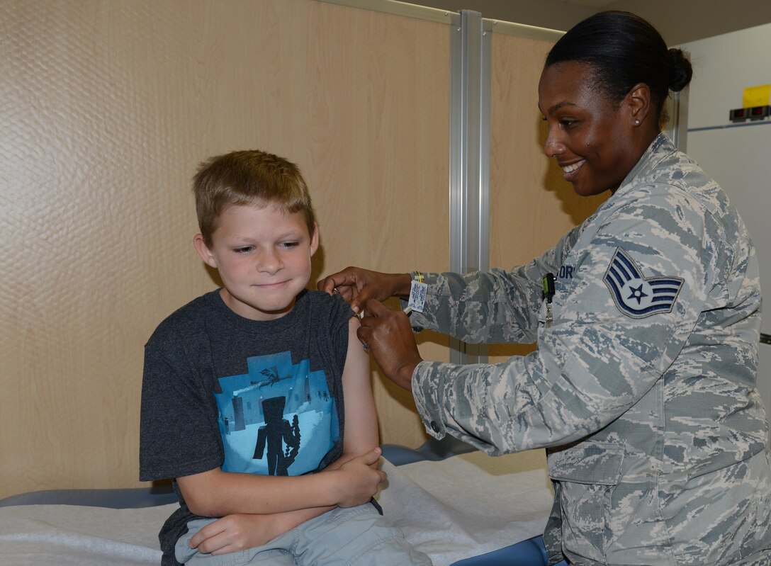 U.S. Air Force Staff Sgt. Adele Dailey-Thomas, 633rd Medical Operations Squadron Allergy and Immunizations Clinic noncommissioned officer-in-charge, gives a vaccine to Kevin Deeger, age 10, son of Tech. Sgt. Doug Seeger, 1st Aircraft Maintenance Squadron flight line expediter, at the pediatric immunization clinic at Langley Air Force Base, Va., Aug. 31, 2016. All school-aged children are required to get certain vaccines before starting school in the state of Virginia. (U.S. Air Force photo by Staff Sgt. Teresa J. Cleveland)