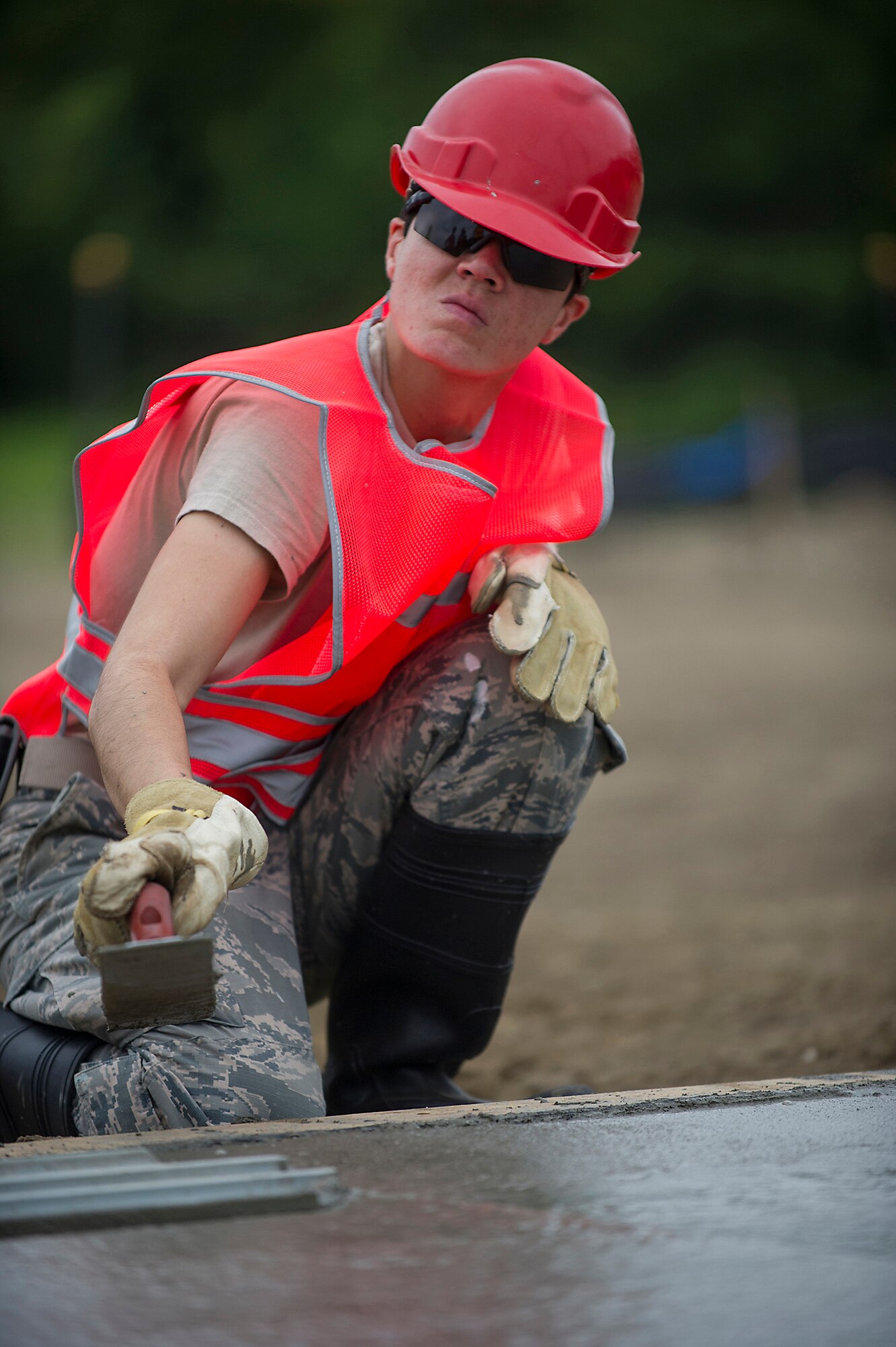 Senior Airman Natalie Guzman, 560th RED HORSE Squadron at Joing  Base Charleston, South Carolina, uses a float to smooth a concrete foundation during a construction project at Joint Base Charleston.  Members of the 560th RHS, 628th Civil Engineer Squadron at Joint Base Charleston, 556th RHS, 555th RHS from Nellis Air Force Base, Nevada, and 567th RHS from Seymour Johnson Air Force Base, North Carolina joined forces June, July and August at Joint Base Charleston to build a 4,800 square-foot preengineered  building building to store 560th RHS construction equipment and gear.  Rapid Engineer Deployable, Heavy Operational Repair Squadron, Engineer (RED HORSE) squadrons provide the Air Force with a highly mobile civil engineering capability in support of contingency and special operations worldwide. They are self-sufficient, mobile squadrons that provide heavy construction support such as runway/facility construction, electrical upgrades, and equipment transport when requirements exceed normal base civil engineer capabilities and where Army engineer support is not readily available. (U.S. Air Force Photo by Michael Dukes)