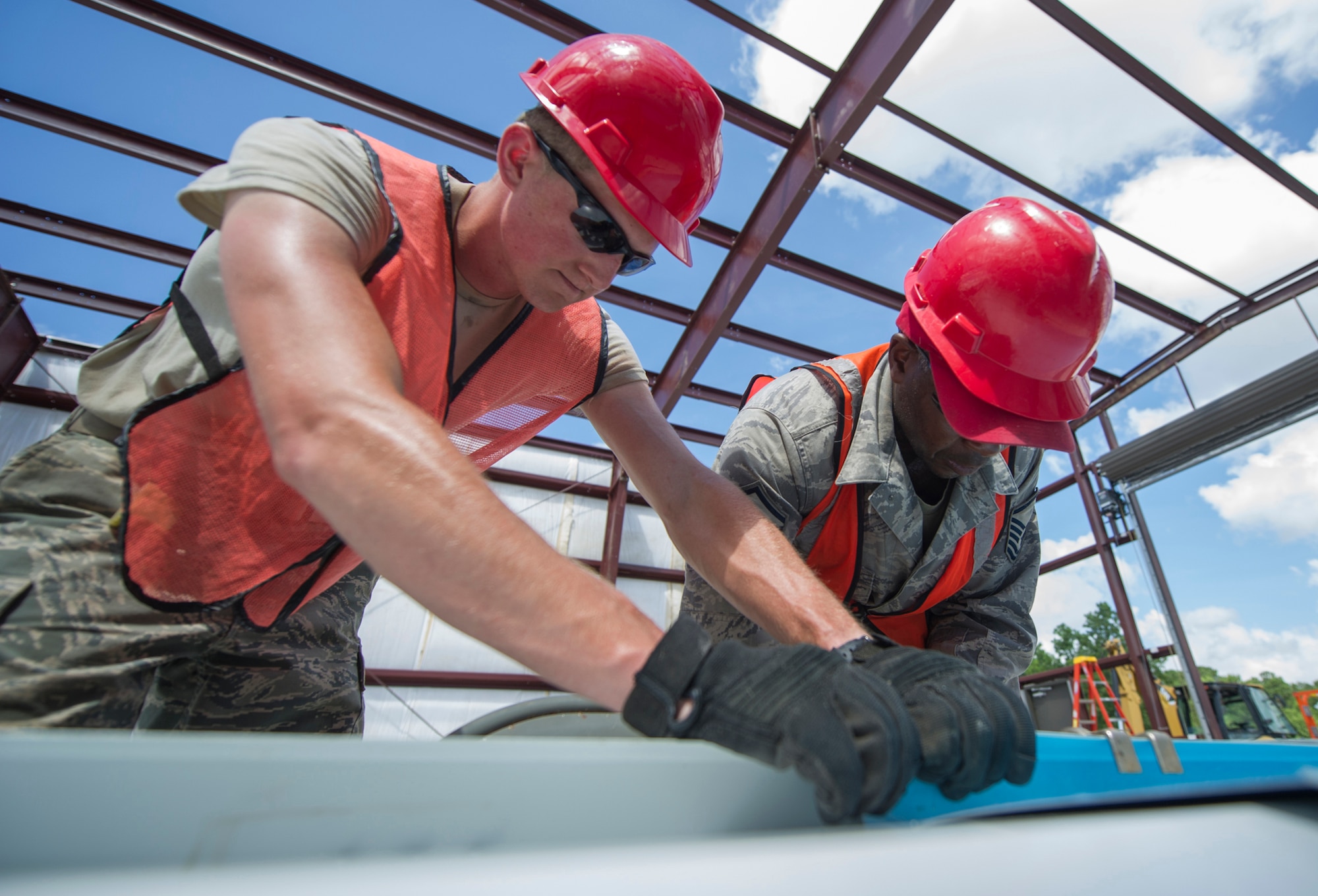 (From left) Senior Airman Brogen Carmichael and Master Sgt. David Robinson, both 560th RED HORSE Squadron Reservists at Joint Base Charleston, South Carolina, assemble one of two rolling door covers during a construction project at Joint Base Charleston.  Members of the 560th RHS, 628th Civil Engineer Squadron at Joint Base Charleston, 556th RHS, 555th RHS from Nellis Air Force Base, Nevada, and 567th RHS from Seymour Johnson Air Force Base, North Carolina joined forces June, July and August at Joint Base Charleston to build a 4,800 square-foot preengineered  building building to store 560th RHS construction equipment and gear.  Rapid Engineer Deployable, Heavy Operational Repair Squadron, Engineer (RED HORSE) squadrons provide the Air Force with a highly mobile civil engineering capability in support of contingency and special operations worldwide. They are self-sufficient, mobile squadrons that provide heavy construction support such as runway/facility construction, electrical upgrades, and equipment transport when requirements exceed normal base civil engineer capabilities and where Army engineer support is not readily available. (U.S. Air Force Photo by Michael Dukes)