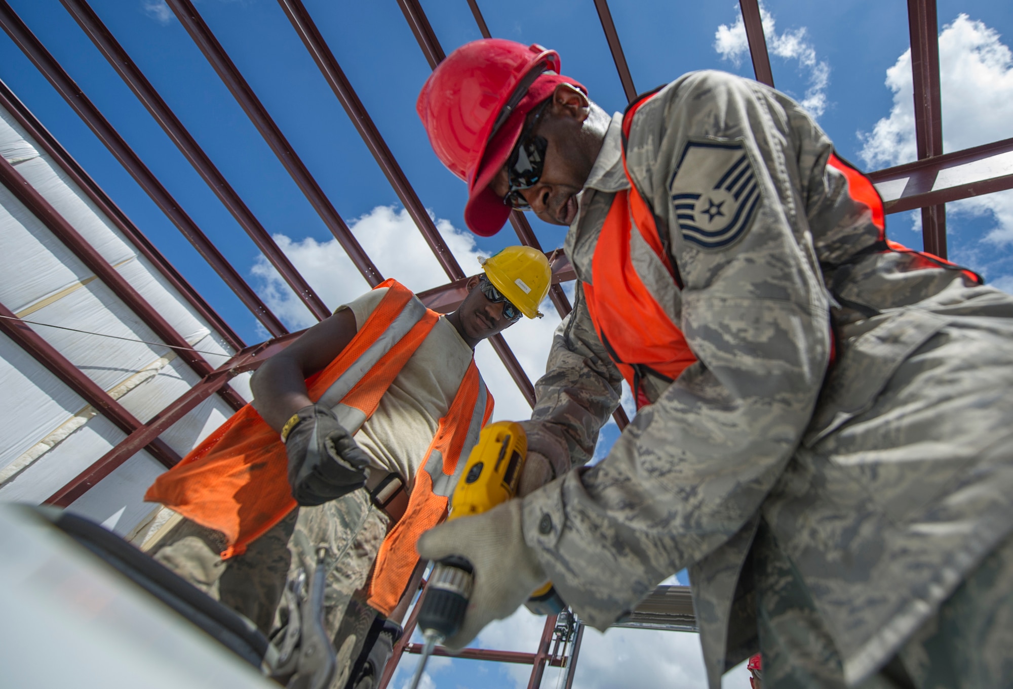(From left) Senior Airman Darrien Anderson and Master Sgt. David Robinson, both 560th RED HORSE Squadron Reservists at Joint Base Charleston, South Carolina, assemble one of two rolling door covers during a construction project at Joint Base Charleston.  Members of the 560th RHS, 628th Civil Engineer Squadron at Joint Base Charleston, 556th RHS, 555th RHS from Nellis Air Force Base, Nevada, and 567th RHS from Seymour Johnson Air Force Base, North Carolina joined forces June, July and August at Joint Base Charleston to build a 4,800 square-foot preengineered  building building to store 560th RHS construction equipment and gear.  Rapid Engineer Deployable, Heavy Operational Repair Squadron, Engineer (RED HORSE) squadrons provide the Air Force with a highly mobile civil engineering capability in support of contingency and special operations worldwide. They are self-sufficient, mobile squadrons that provide heavy construction support such as runway/facility construction, electrical upgrades, and equipment transport when requirements exceed normal base civil engineer capabilities and where Army engineer support is not readily available. (U.S. Air Force Photo by Michael Dukes)