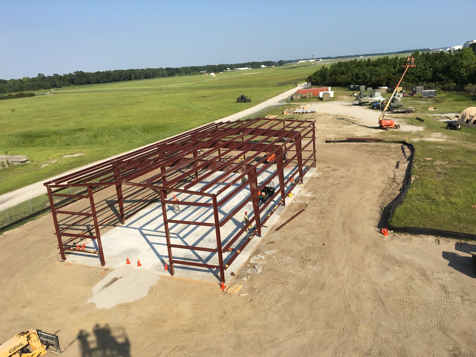 The steel skeleton of a new storage building looks tiny from about 30 feet above a RED HORSE construction site at Joint Base Charleston June 2016.  Members of the 556th RHS from Hurlburt Field, Florida, 555th RHS from Nellis Air Force Base, Nevada, 567th RHS from Seymour Johnson AFB, North Carolina, and the 628th Civil Engineer Squadron at Joint Base Charleston, joined the 560th RHS over a 6 month period to construct a 4,800 square-foot steel frame storage facility.(U.S. Air Force photo by Master Sgt. Thomas Martin, 556th RHS)
