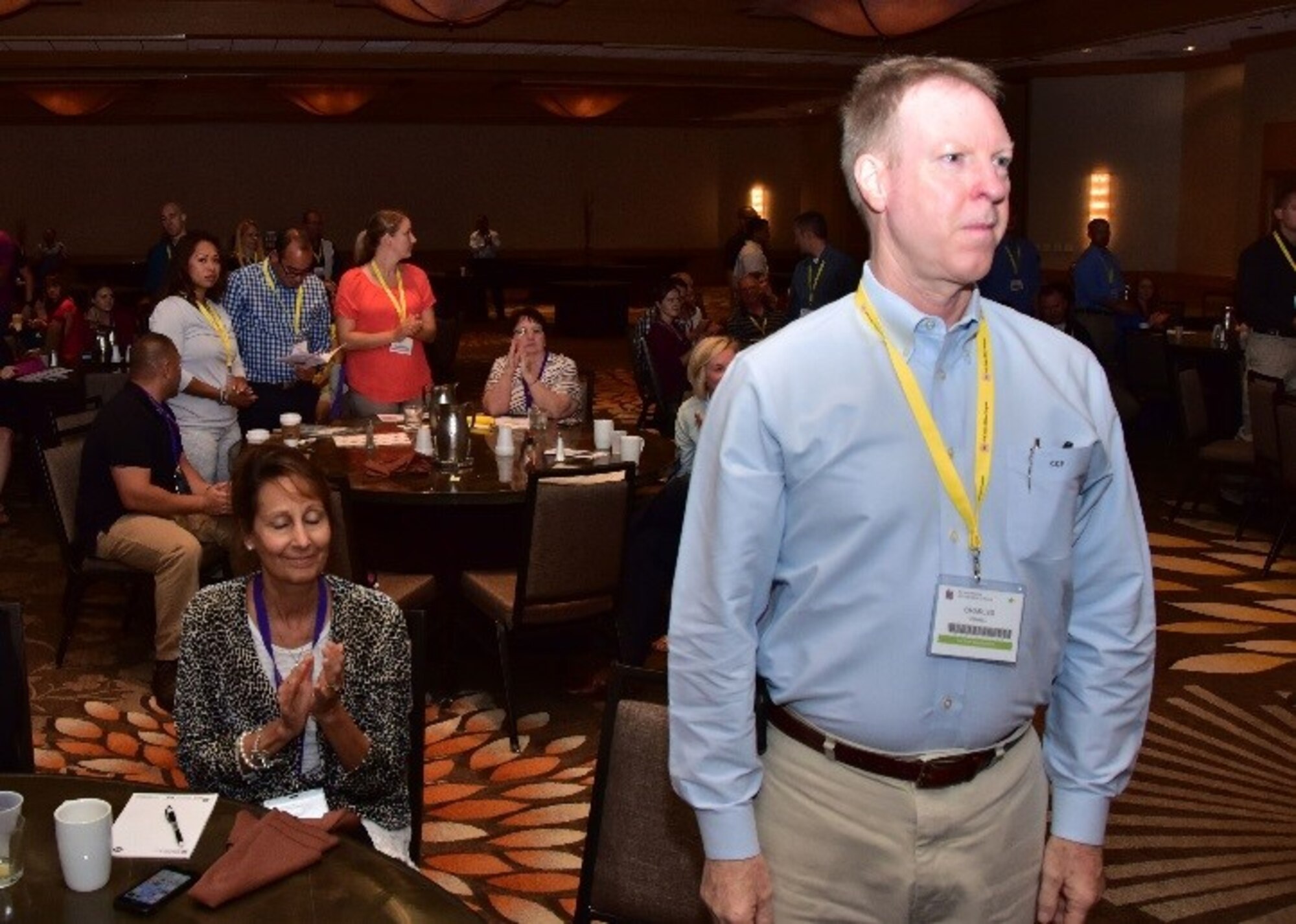 Lt. Col. Charles Powell, 931st Air Reserve Wing flight doctor, McConnell Air Force Base, Kansas, stands while Angeli, his wife, sits behind him clapping as deployers are recognized Aug 26 during a Yellow Ribbon event in Costa Mesa, Ca. (U.S. Air Force photo by Tech. Sgt. Louis Vega Jr.)