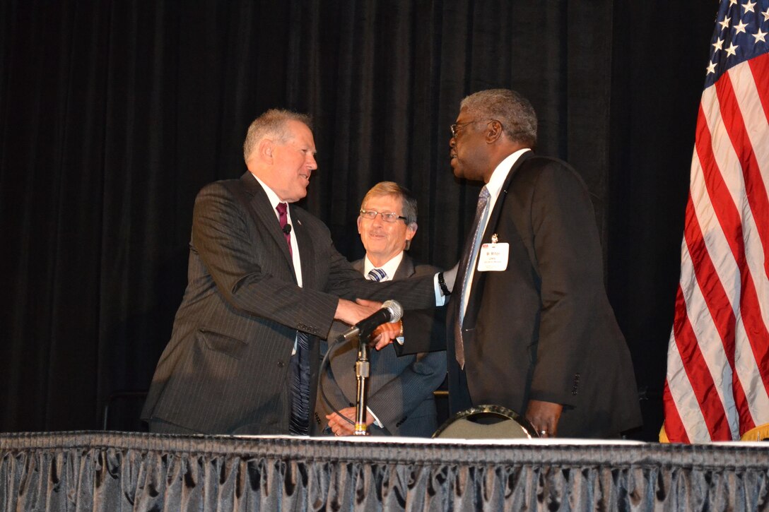 Steve Rodocker (middle), deputy director of DLA Land and Maritime’s Strategic Acquisition Programs, and Milton Lewis (right), DLA Land and Maritime acquisition executive, receive a coin of excellence from Frank Kendall, under secretary of defense for acquisition, technology and logistics Aug. 31 at the DLA Land and Maritime Supplier Conference and Expo in Columbus, Ohio.