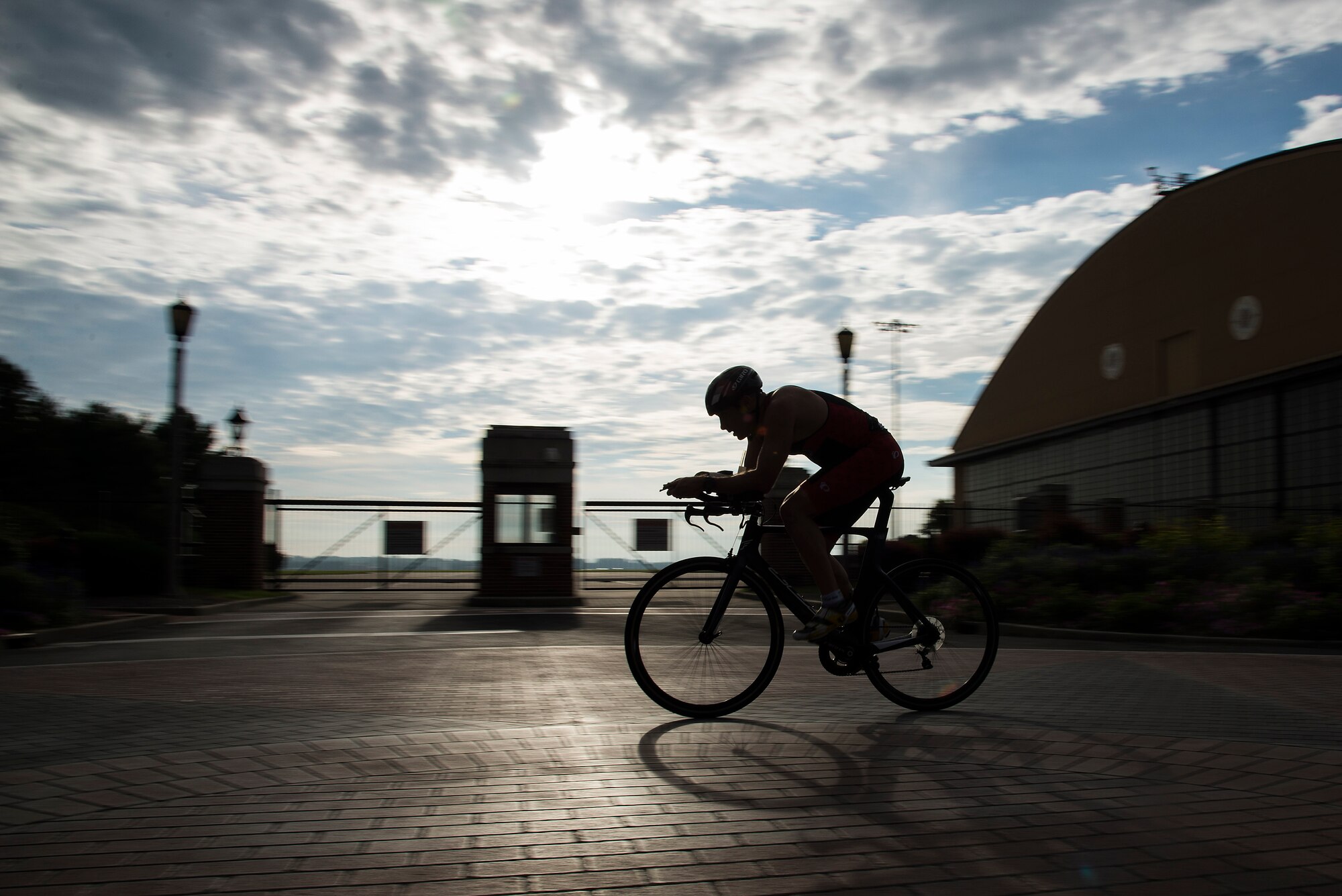 A bicyclist rides past a hangar during the Surface Warrior Challenge at Scott Air Force Base, Ill., Aug. 27, 2016. The event, also known as the Tour de Scott, featured a triathlon consisting of running, bicycling and swimming that participants could compete in individually or as a member of a team. (U.S. Air Force photo by Tech. Sgt. Jonathan Fowler)