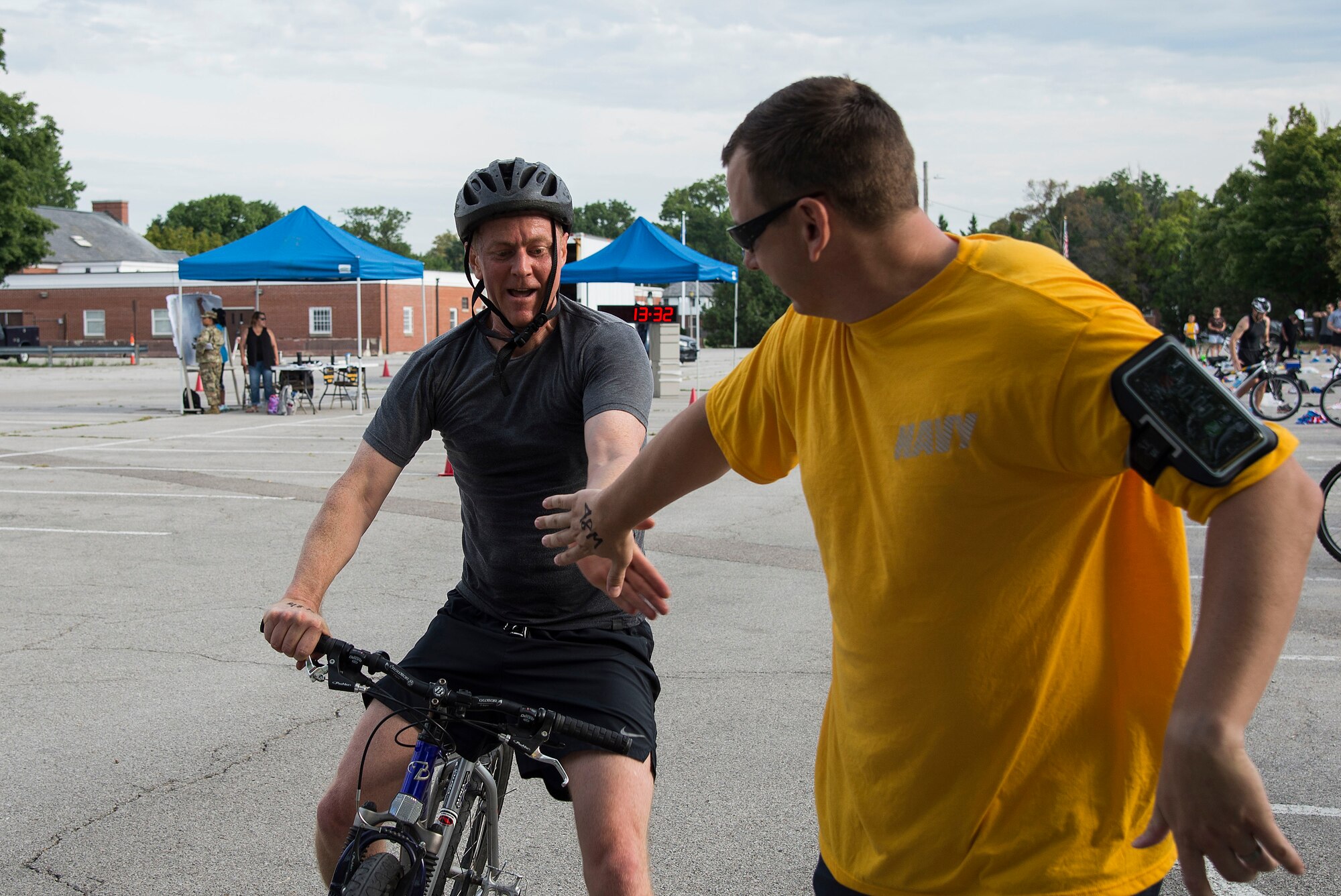 Team members tag each other’s hands as they transition from the bicycle to run portion of the Surface Warrior Challenge at Scott Air Force Base, Ill., Aug. 27, 2016. The triathlon allowed participants to compete both individually and as teams. Additionally, participants could choose between the full triathlon and a miniature one that shortened the distance each portion of the race required. (U.S. Air Force photo by Tech. Sgt. Jonathan Fowler)