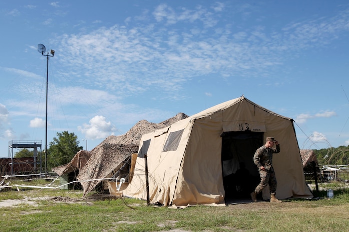 Sgt. Austin Cardwell walks out of a tent in front of a Tactical Elevated Antenna Mast System during a field exercise conducted by Alpha Company, Marine Wing Communications Squadron 28, aboard Marine Corps Air Station Cherry Point, N.C., Aug. 23, 2016. The two-week exercise occurs annually to satisfy training and readiness requirements and serve as an opportunity for Marines to reaffirm previously learned skillsets. Cardwell is a cyber-network operator with MWCS-28. (U.S. Marine Corps photo by Cpl. Jason Jimenez/Released)

