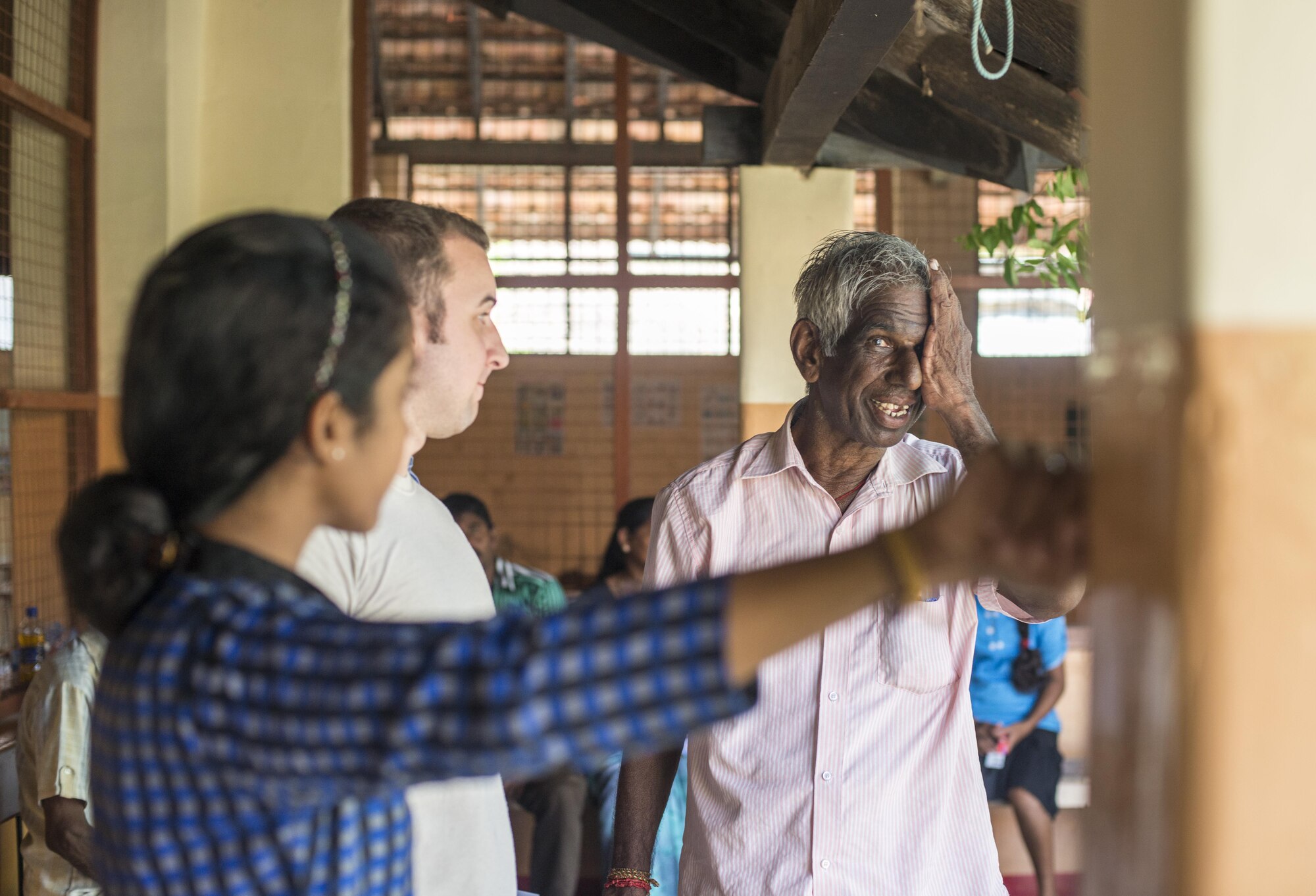 A Sri Lanka man gets his vision checked by a U.S. Airman while a translator provides assistance during Pacific Angel (PACANGEL) 16-3 in Jaffna, Sri Lanka, Aug. 17, 2016. PACANGEL is a total force, joint and combined humanitarian assistance/civil military operation led by U.S. Pacific Air Forces. Assistance during PACANGEL included general health, dental, optometry and physical therapy. (U.S. Air Force photo by Senior Airman Brittany A. Chase)