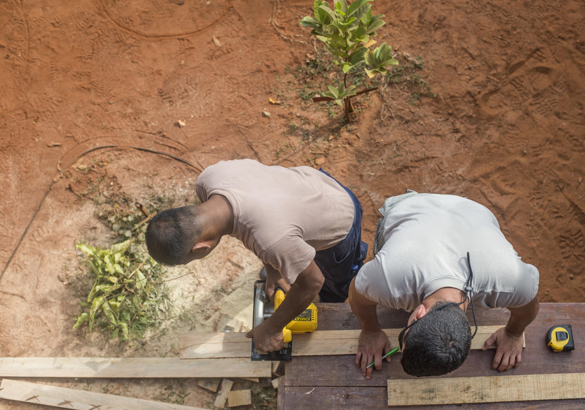 U.S. Air Force Senior Airman Jonathon Sikora, 354th Civil Engineering Squadron structures journeyman, holds a 2x4 while a Sri Lankan Air Force engineer makes a cut, during Pacific Angel 16-3, at Jaffna, Sri Lanka Aug. 20, 2016. Operation PACANGEL is a total force, joint and combined humanitarian assistance/civil military operation led by United States Pacific Air Forces. The civil engineering team poured concrete pads, repairs roofs, updated plumbing, remodeled washrooms, built chalk boards and put in a drive way for six different schools, impacting more than 1,100 Sri Lankan children. (U.S. Air Force photo by Senior Airman Brittany A. Chase)