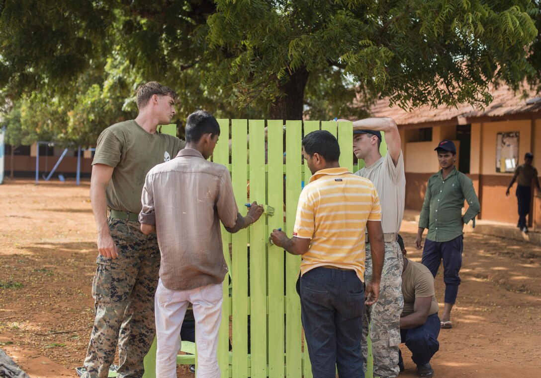 Members from the U.S. Air Force, Marines and local contractors paint a picnic table during Pacific Angel 16-3, at Jaffna, Sri Lanka Aug. 20, 2016. Operation PACANGEL is a total force, joint and combined humanitarian assistance/civil military operation led by United States Pacific Air Forces. The civil engineering team poured concrete pads, repairs roofs, updated plumbing, remodeled washrooms, built chalk boards and put in a drive way for six different schools, impacting more than 1,100 Sri Lankan children. (U.S. Air Force photo by Senior Airman Brittany A. Chase)