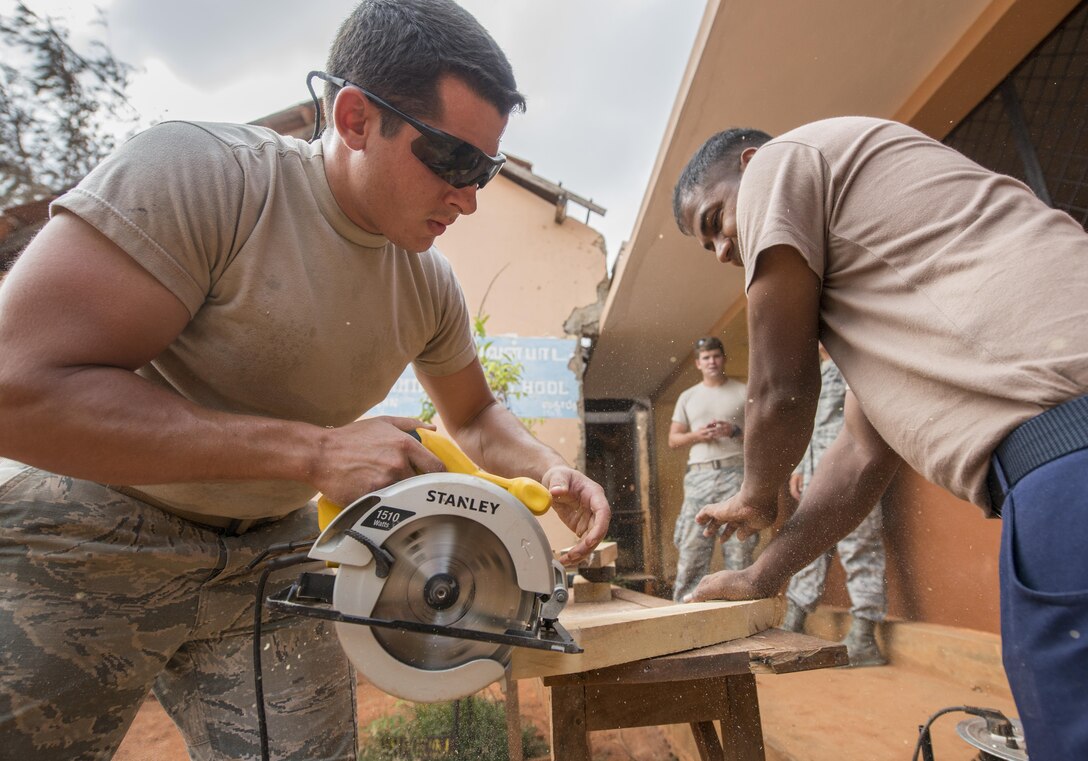U.S. Air Force Senior Airman Jonathon Sikora, 354th Civil Engineering Squadron structures journeyman, cuts a 2x4 with assistance from a Sri Lankan Air Force engineer, during Pacific Angel 16-3, at Jaffna, Sri Lanka Aug. 20, 2016. Operation PACANGEL is a total force, joint and combined humanitarian assistance/civil military operation led by United States Pacific Air Forces. The civil engineering team poured concrete pads, repairs roofs, updated plumbing, remodeled washrooms, built chalk boards and put in a drive way for six different schools, impacting more than 1,100 Sri Lankan children. (U.S. Air Force photo by Senior Airman Brittany A. Chase)